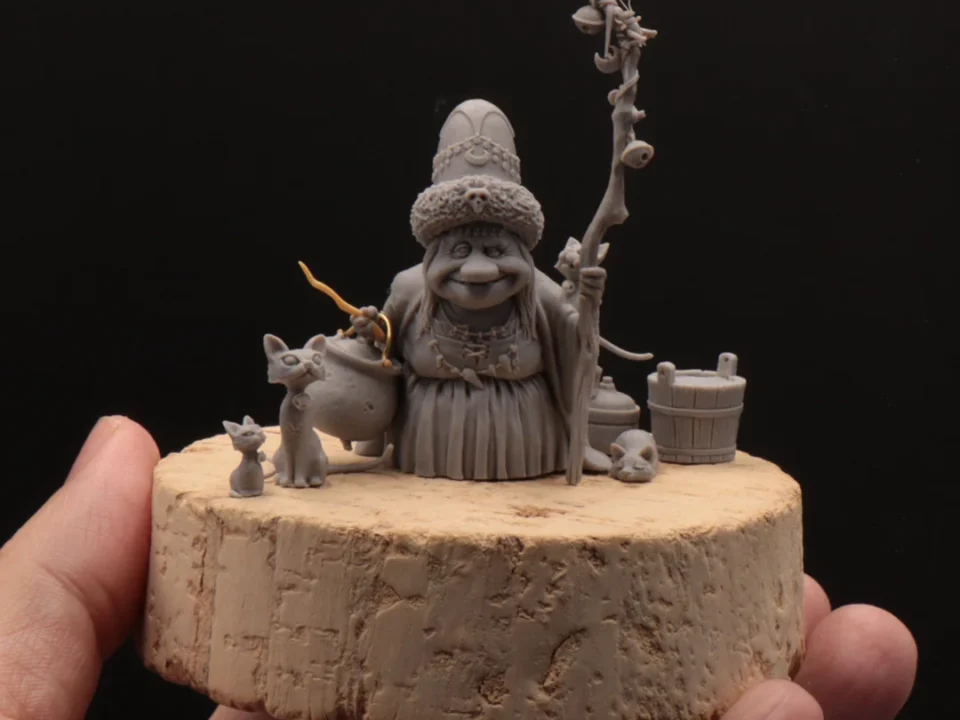 Small handcrafted miniature statue of a seated figure surrounded by animals on a table