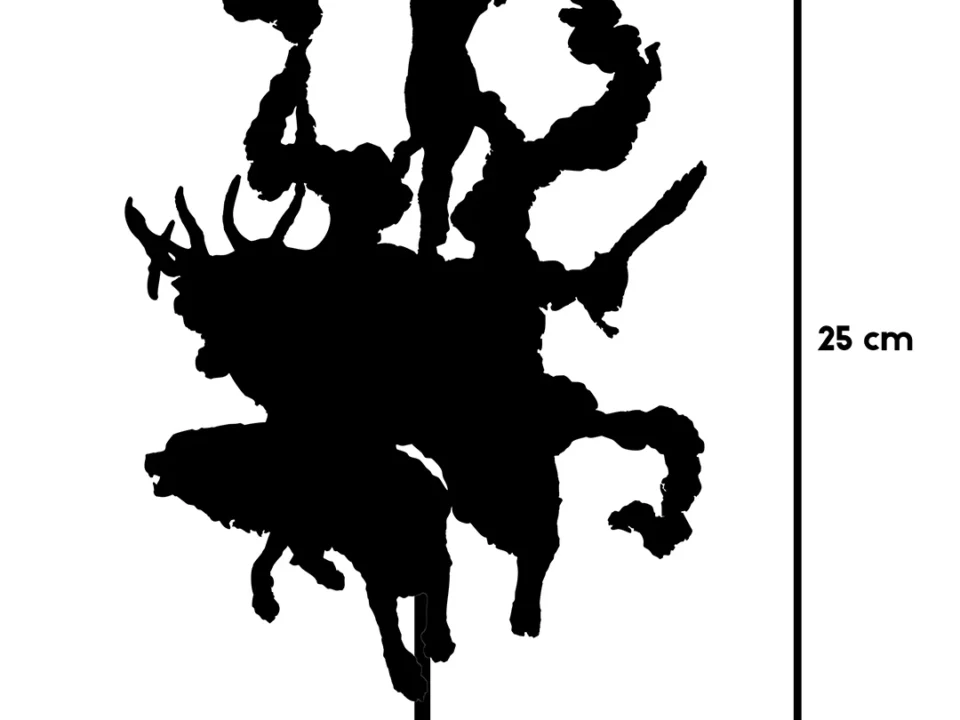 Handcrafted metal sculpture of a dancing figure in the center, surrounded by abstract silhouettes of people in black